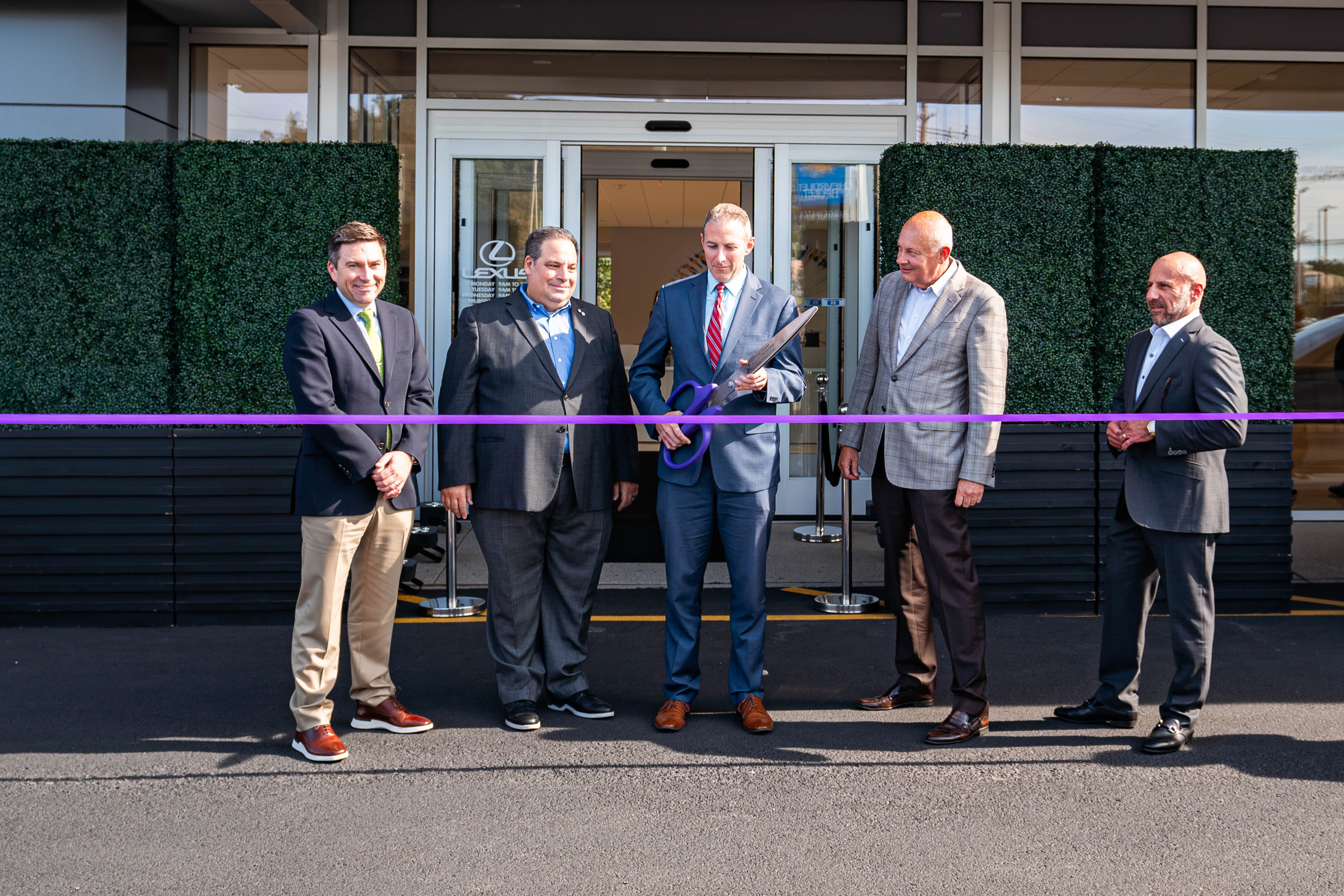 President of Kollective Bill Berardino at Lexus of Bridgewater cutting ribbon at the grand reopening of the dealership's showroom with a Lexus RZ test drive event.