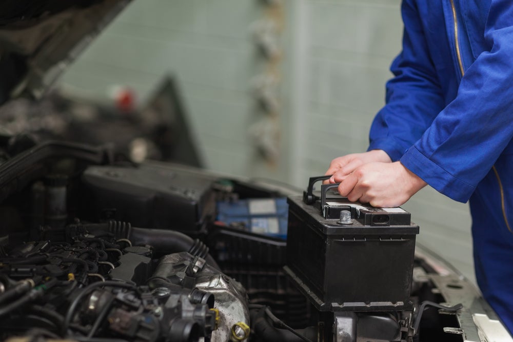 Service technician working on a car battery