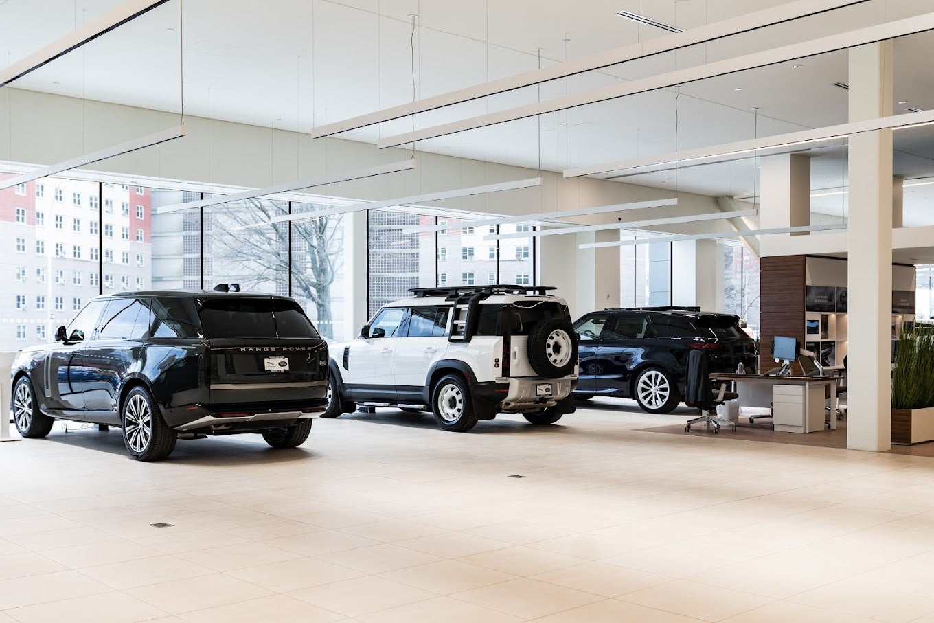 Rear view of three luxury SUVs, inside Land Rover Brooklyn